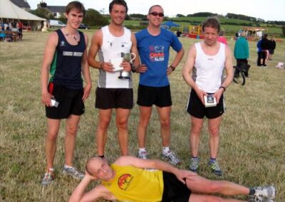 Adult Runners showing trophies on the field